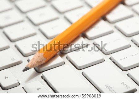 Closeup concept of a lead pencil on top of a modern computer keyboard