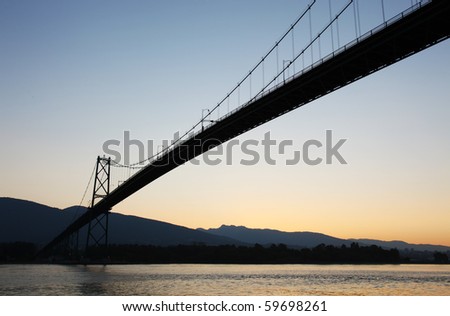 Lions Gate Bridge silhouetted against the early morning sunlight