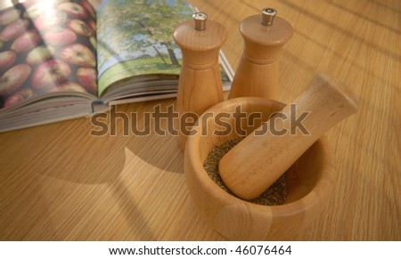 Herbs with salt and pepper herbs in a bowl book in the background