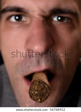 closeup of male preparing to light a Cuban cigar, selective focus on cigar tip