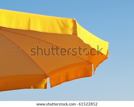 yellow parasol abstract isolated against clear blue sky