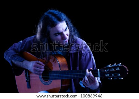Man Playing Classical Guitar on Black Background