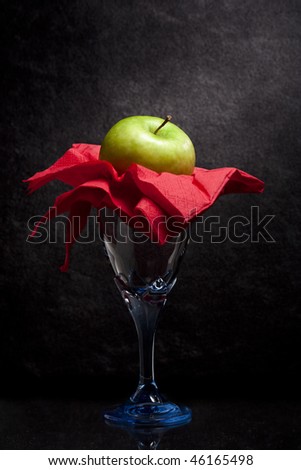 Green Apple on a Glass, with Red Tissue