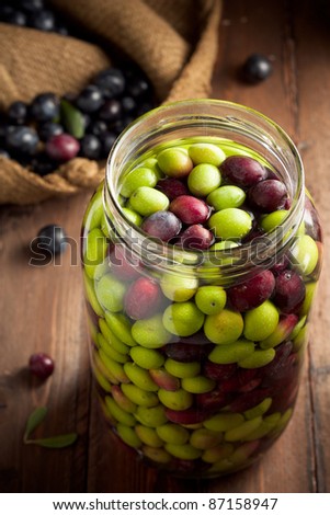 Olives in Brine (with Water and Salt in Glass Jar) on Wood