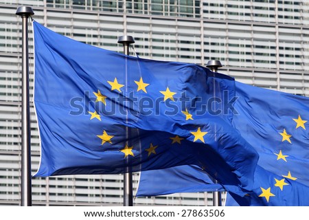 European flags floating in front of the European Commission Building in Brussels, wind blowing from the left
