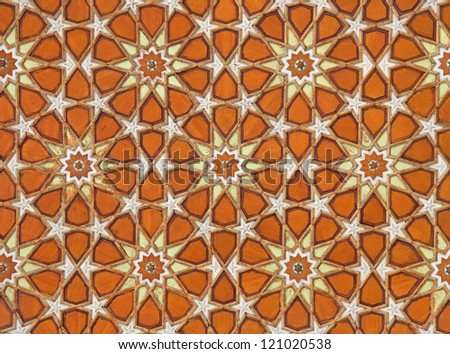 Very old orange and yellow Islamic arabesque pattern with ornamental flower shaped designs on the ceiling.
