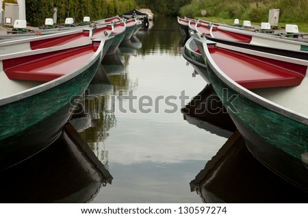 Colorful rental boats parked on a canal in beautiful village of Giethoorn in Netherlands.