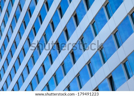 Exterior of a contemporary skyscraper with Converging panes of glass windows.