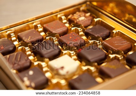 Golden box of fine handmade chocolates in different colors and kinds.