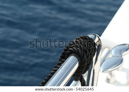 Polished Railing and Cleat with a black rope on a super-yacht with ocean in the background