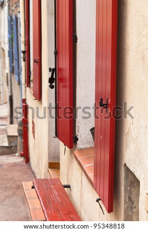 Houses with red shutters in a row in a small village in Provence in France.
