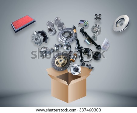 Many spare parts flying out of the box on gray background. Auto parts