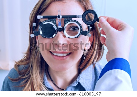 Girl woman in messbrille glasses in ophthalmology clinic. Ophthalmic glasses for diopter detection.