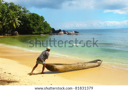 Man pushing a traditional canoe in Madagascar
