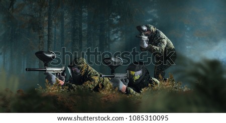 Paintball team shooting in forest battle