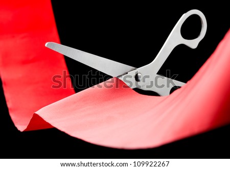 Closeup of scissors cutting a red ribbon