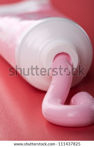 Pink toothpaste squeezing out of tube