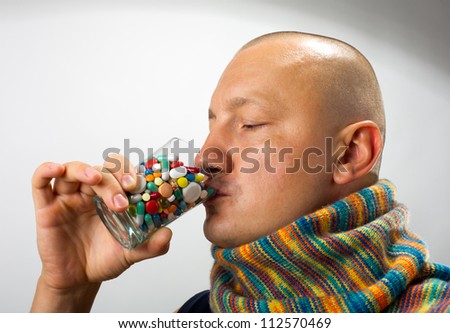 Ill man drinking cocktail of colorful pills