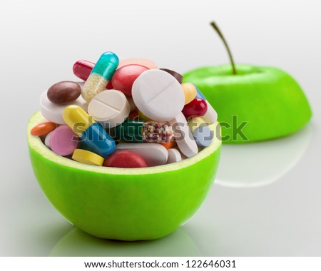 Open ripe apple full of colorful medicines