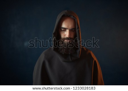 Portrait of medieval monk in black robe with hood