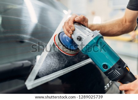 Worker removes the track from wiper blade on car
