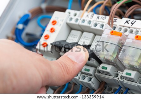 Hand of an electrician turning on a fusebox