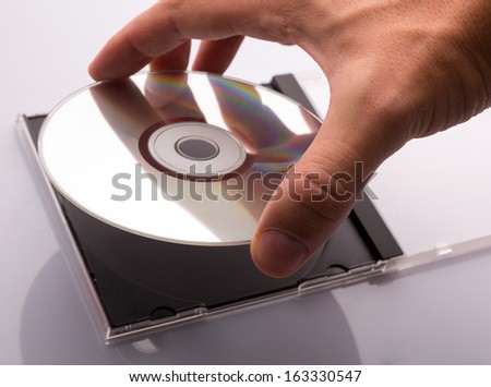 hand taking DVD disc from box.