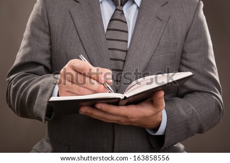 Young man in a suit takes notes