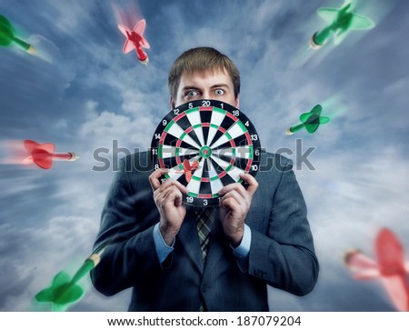 Businessman holding darts board in his hands