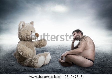 Strange naked man looks at toy bear