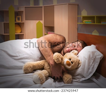 Sleeping man in bed with toy bear
