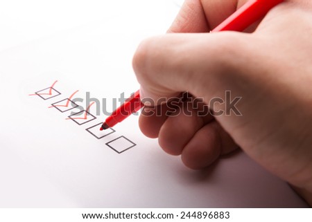 Hand with pen and check boxes