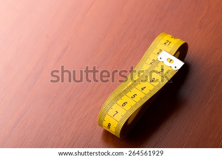 Closeup of measurement tape on the wooden table with space