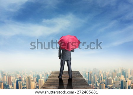 Man with umbrella standind on the pier