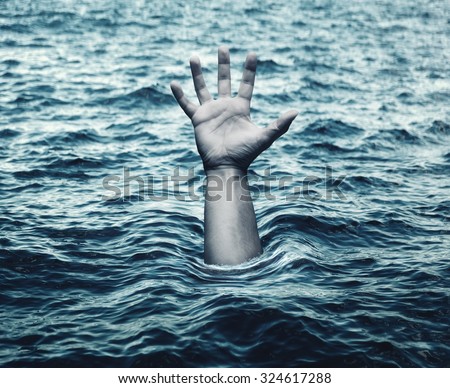 Hand of drowning man in sea