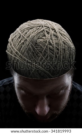 Young man with closed eyes and with balls of yarns instead of his brain