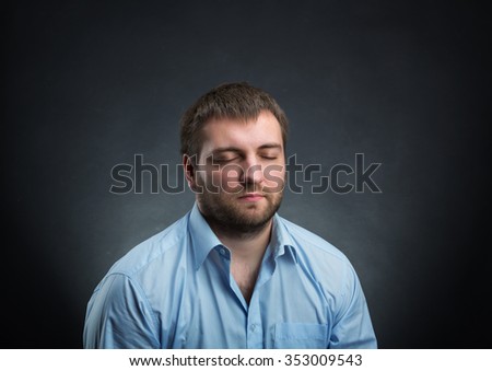Man wearing blue shirt dreaming with closed eyes over black