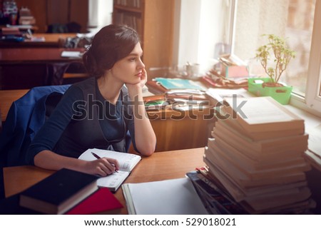Serious woman thinking in library silence.