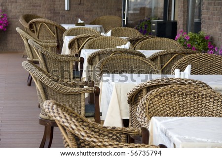 Outdoor cafe. Row of rattan chairs and tables