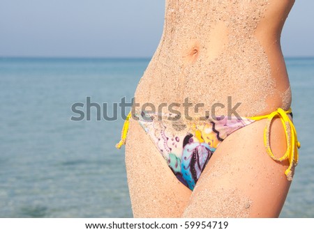 Hot and wet. Close-up of sandy woman perfect body