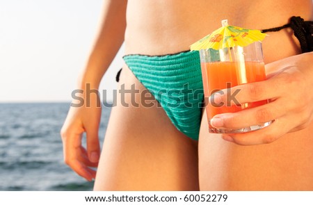 Tan woman with cocktail on the beach