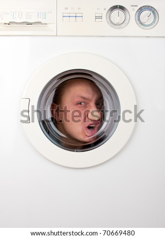 Close-up of bizarre man inside washing machine - stock photo