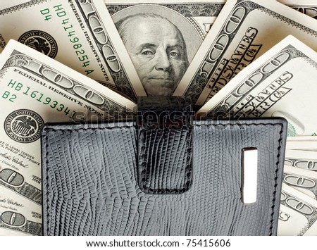 Black leather wallet on heap of money