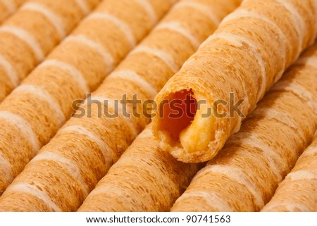 Close-up of striped wafer rolls filled with cream
