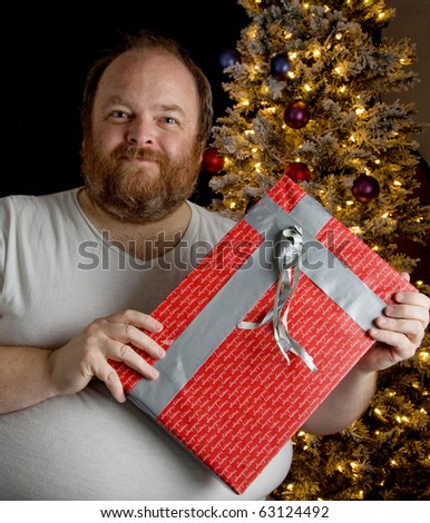 Obese man wrapping christmas present with duct tape