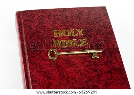 Bible with key against white background