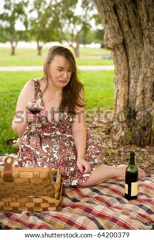 Woman making a face after sipping some bad wine on a picnic