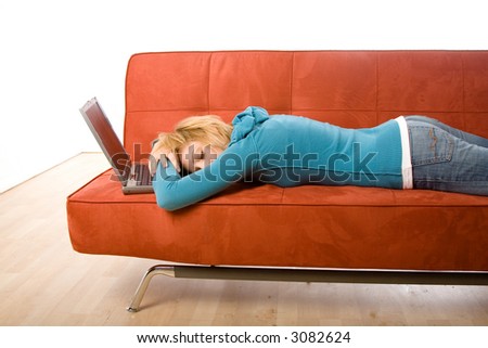 Young woman sleeping on a couch next to a laptop