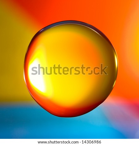 Orange water drop over red/orange/blue coloured background