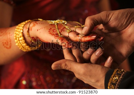 Close up of Indian couple\'s hands at a wedding, concept of marriage/partnership/commitment